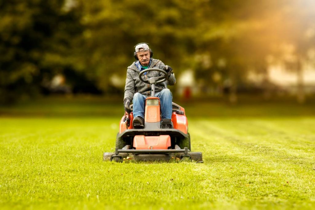 person riding lawn mower